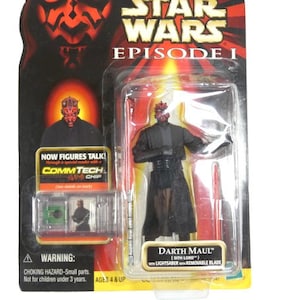 May include: A Star Wars Episode I action figure of Darth Maul, a Sith Lord, with a red lightsaber. The figure is packaged in a plastic blister pack with a red and black background. The packaging includes the text "NOW FIGURES TALK! COMMTECH CHIP" and "AGES 4 & UP".