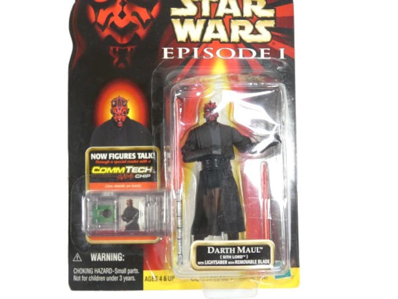 May include: A Star Wars Episode I action figure of Darth Maul, a Sith Lord, with a red lightsaber. The figure is packaged in a plastic blister pack with a red and black background. The packaging includes the text "NOW FIGURES TALK! COMMTECH CHIP" and "AGES 4 & UP".