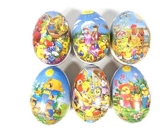 May include: Six colorful Easter eggs with different designs featuring bunnies, chicks, and other Easter-themed imagery. The eggs are made of cardboard and have a glossy finish.