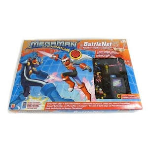 May include: A boxed MegaMan Battle Network toy set. The box features action figures of MegaMan and another character in a battle scene. The set includes several small action figures and a small screen. The box is orange, blue, and yellow.