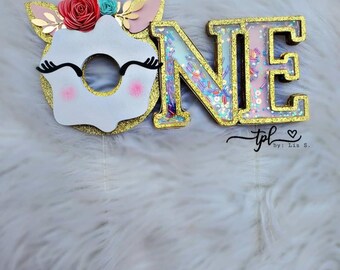 UN adorno para tarta con temática de donut y unicornio