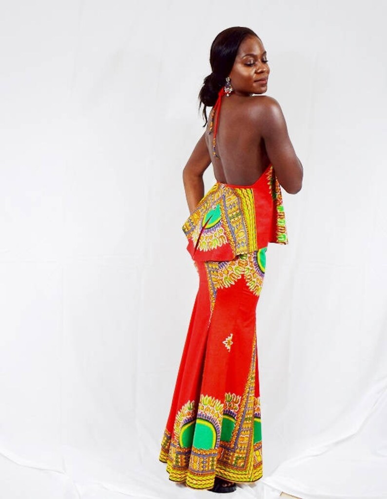 May include: A red and green maxi dress with a halter top and a fitted skirt. The dress features a colourful African print pattern.