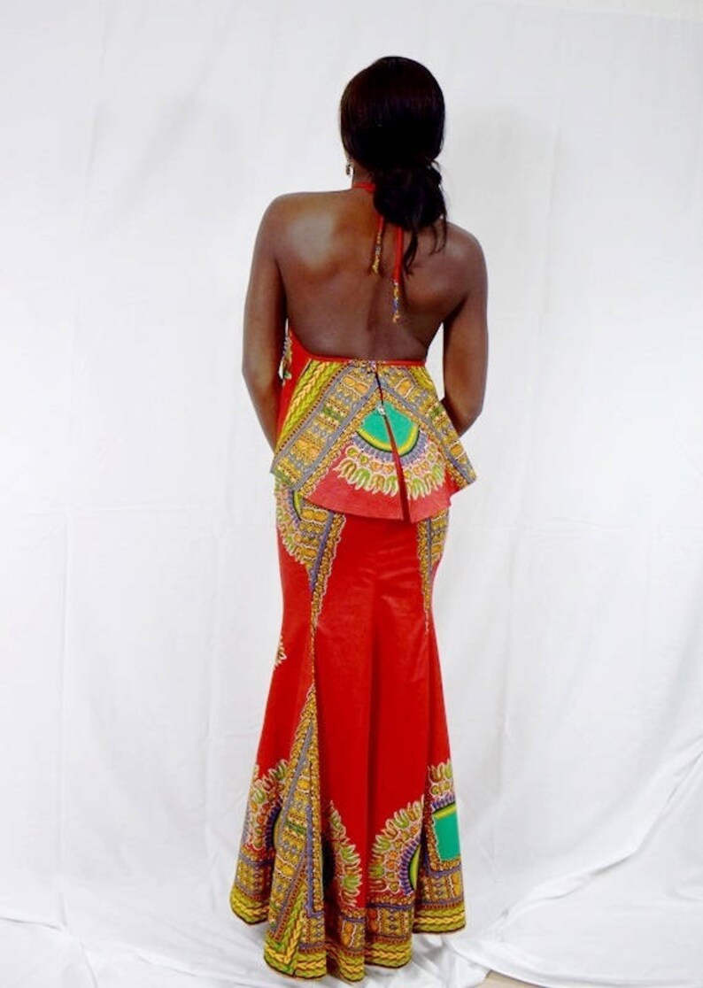 May include: A red maxi dress with a colourful patterned skirt and a halter top. The dress has a fitted bodice and a flowing skirt.