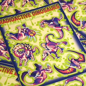 May include: A set of stickers featuring a variety of colourful, cartoon-style dinosaurs with a radioactive theme. The stickers are on a green background with black and blue borders. The text "RADIOACTIVE DINOSAURS" is printed on the stickers.