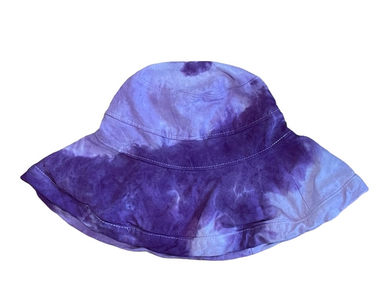 May include: A purple and white tie-dye bucket hat with a wide brim.