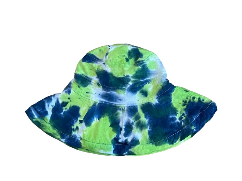 May include: A green and blue tie-dye bucket hat. The hat has a wide brim and is made of a soft, comfortable fabric.