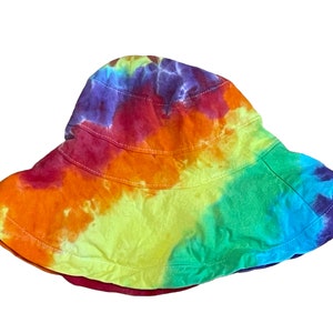 May include: A tie-dye bucket hat with a rainbow pattern in shades of red, orange, yellow, green, blue, and purple.