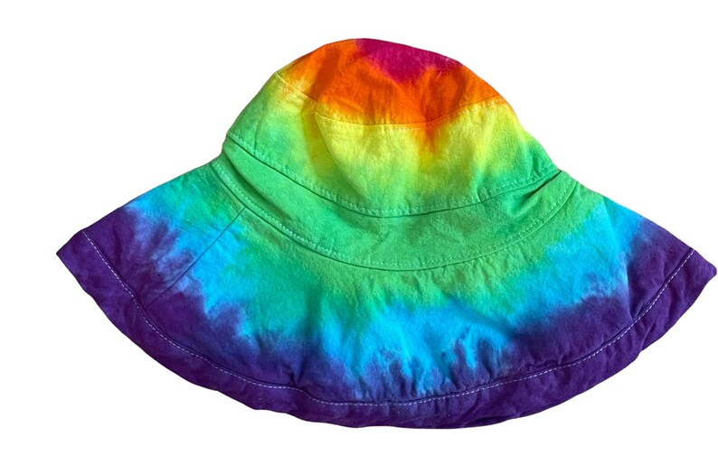 May include: A rainbow tie-dye bucket hat with a wide brim and a purple band around the bottom.