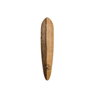 May include: A longboard skateboard deck made of wood with a dark brown stain. The deck has a rounded nose and tail and a logo of a tree in a circle on the bottom.