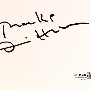 May include: A white card with a black handwritten signature. The signature includes the name "Drake" and the initials "D.H.". The card also has a JSA authentication sticker and QR code.