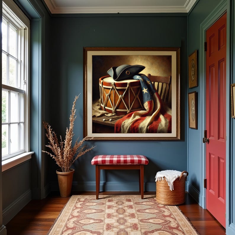 May include: A framed wall art print depicting a vintage drum with a tricorn hat and an American flag draped over it, resting on a wooden surface. The composition includes two drumsticks placed on the table next to the drum and a wooden chair.