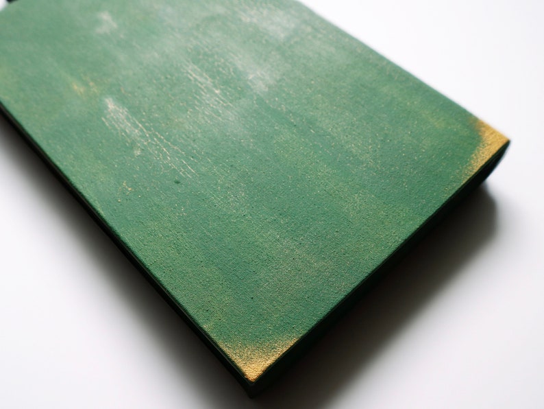May include: A green wooden sign with a distressed finish and a gold edge. The sign is blank and ready to be painted or decorated.