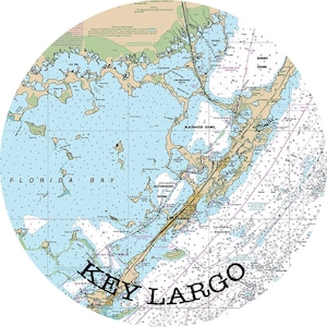 May include: A nautical chart of Key Largo, Florida, showing the waterways and islands in the area. The chart is in a circular format and features the text "KEY LARGO" in large, bold letters.