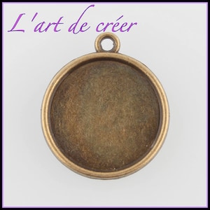 May include: A round, antique gold-toned metal pendant with a smooth, circular surface. The pendant has a loop at the top for attaching a chain or cord.