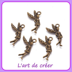 Peut inclure: Cinq breloques en métal doré antique en forme de fées avec des ailes. Chaque breloque a une boucle en haut pour l'attacher à un collier, un bracelet ou un autre bijou.