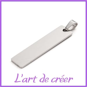 Puede incluir: Un colgante rectangular de plata con una superficie lisa y pulida. El colgante tiene un bucle en la parte superior para sujetarlo a una cadena o cordón.