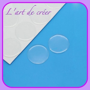 May include: A sheet of clear adhesive round stickers on a white background. Two stickers are shown on a blue surface.