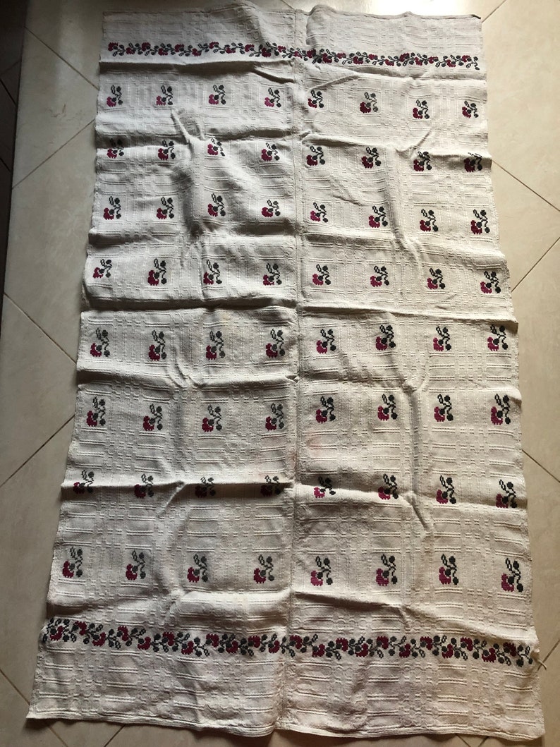 Peut inclure: Une nappe en lin blanche avec un motif r&eacute;p&eacute;t&eacute; de petites fleurs rouges et noires. La nappe a une bordure de fleurs rouges et noires.