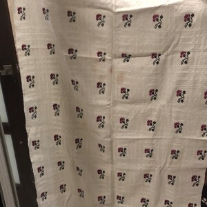 Peut inclure: Nappe en lin blanc avec un motif r&eacute;p&eacute;t&eacute; de petites fleurs rouges et noires. La nappe a une bordure de fleurs rouges et noires.