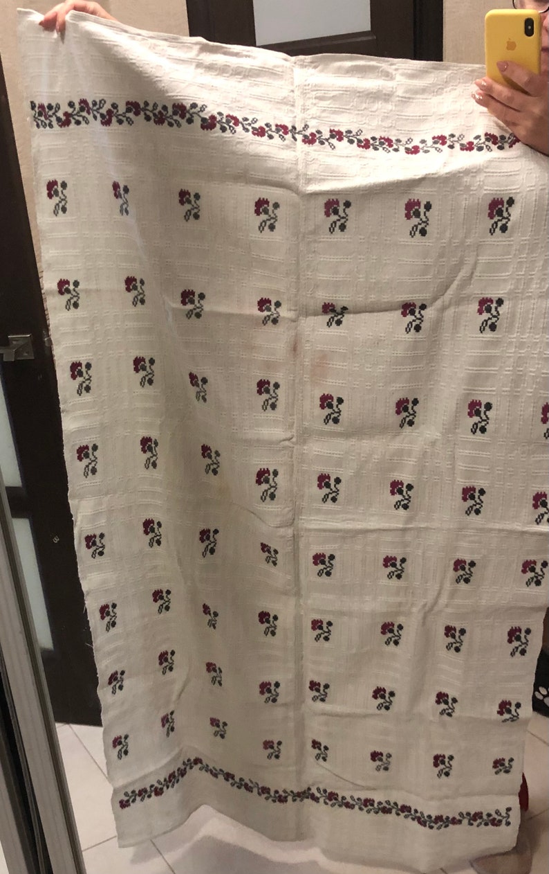 Peut inclure: Nappe en lin blanc avec un motif r&eacute;p&eacute;t&eacute; de petites fleurs rouges et noires. La nappe a une bordure de fleurs rouges et noires.