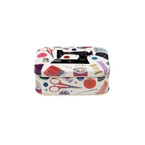 May include: A rectangular sewing kit tin with a white background and a colourful pattern of sewing tools. The design includes a black sewing machine, red scissors, spools of thread, and buttons. The tin is a charming storage solution for sewing supplies.