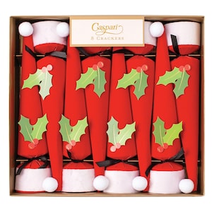 May include: A box of eight red and white Christmas crackers with holly and berry designs. The crackers are shaped like Santa hats and have black ribbon ties. The box has a gold background and the text "Caspari 8 Crackers" printed on it.