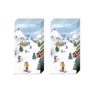 May include: A pack of 20 tissue paper napkins with a winter scene of skiers on a snowy mountainside with a ski lift and houses. The napkins are white with blue, red, green, and yellow accents.