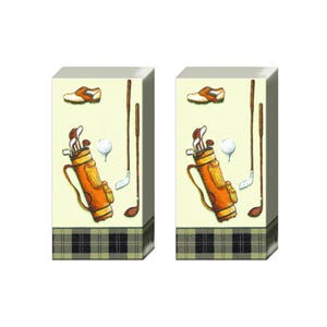 May include: Two stacks of rectangular paper napkins featuring a cream background with illustrations of a brown golf bag, golf clubs, a white golf ball, and a brown and white golf shoe. The bottom edge has a black and green plaid pattern.