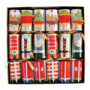 May include: A box of 12 Christmas crackers featuring a nutcracker design. The crackers are red, green, and white with gold accents. Each cracker has a festive design with a nutcracker face and a gold ribbon.