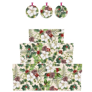 May include: Three round Christmas decorations with white flowers, pine cones, and greenery hang above three rectangular gift boxes. The boxes feature a repeating pattern of white flowers, pine cones, holly, and ferns on a cream background.
