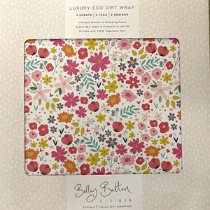 Puede incluir: Una caja de papel de regalo ecológico de lujo con un estampado floral colorido. El papel presenta flores rosas, amarillas y naranjas sobre un fondo blanco. La caja incluye 4 hojas, 2 etiquetas y 2 diseños. El texto "Belly Button Designs" es visible.