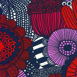 May include: Close-up of a colourful floral pattern in red, pink, white, and navy blue. The design features stylized flowers and geometric shapes. The pattern is a close-up view, showcasing the intricate details and vibrant colours.
