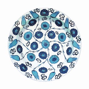 May include: A white ceramic plate with a blue and white floral design. The design features stylised flowers and leaves, with a repeating pattern of blue tulips.