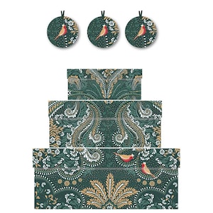 Könnte beinhalten: Drei grüne und goldene Geschenkboxen mit einem roten Vogelmuster. Die Boxen sind übereinander gestapelt, wobei die größte Box unten und die kleinste Box oben liegt. Die Boxen sind mit einem Paisley-Muster und einem kleinen roten Vogel mit gelbem Schnabel verziert.
