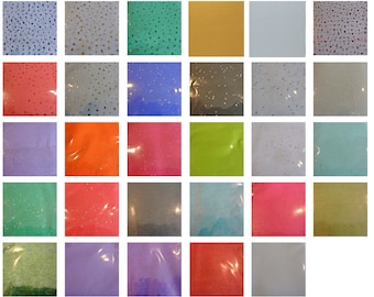 May include: A collection of 25 small squares of glitter sand in various colors, including green, blue, red, orange, purple, and gold. The sand is packaged in clear plastic bags.