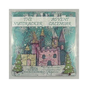 May include: A teal blue advent calendar featuring a pink and gold castle with a snowy background. The text "The Nutcracker Advent Calendar" is printed on the front. The calendar is a build-your-own with slot-in pieces. The text "Build Day by Day with Slot-in Pieces" is printed below the castle. The text "Christmas wouldn't be Christmas without the Nutcracker" is printed on the right side of the castle.