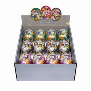 May include: A display box filled with decorative Easter eggs. Each egg is oval-shaped and features a colorful floral design. The eggs are arranged in rows within a gray cardboard box, with a header that reads "Cloisonne Eggs".