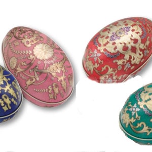 May include: Four decorative Easter eggs with intricate gold designs on a white background. The eggs are blue, pink, red, and green.