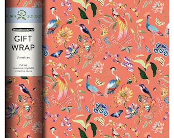 Peut inclure: Papier cadeau corail avec un motif floral et faunique vibrant. Le motif comprend des oiseaux colorés, des papillons et des fleurs. Le texte "GIFT WRAP" est visible sur le côté du rouleau.