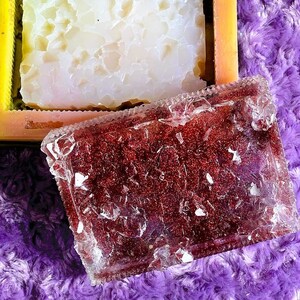 May include: Two rectangular resin molds, one clear with red glitter and one white with a cracked ice effect. The molds are on a purple fuzzy surface.