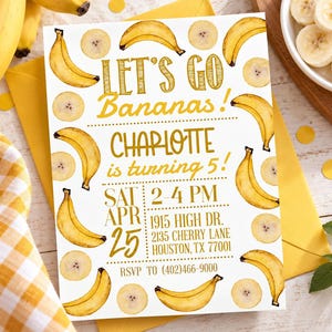 May include: A white rectangular birthday invitation card featuring yellow banana illustrations and banana slices. The text reads: LET'S GO Bananas! CHARLOTTE is turning 5! SAT APR 25 2-4 PM 1915 HIGH DR. 2135 CHERRY LANE HOUSTON, TX 77001 RSVP TO (402)466-9000.