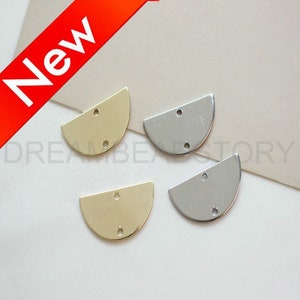 May include: Four half-circle metal charms with two holes each. Two charms are gold and two are silver.