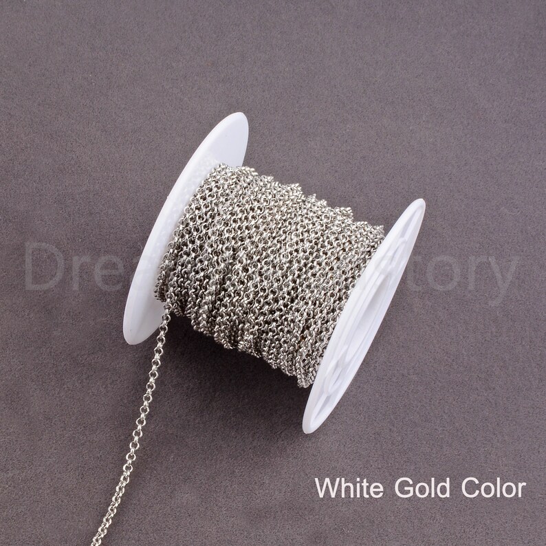 Peut inclure: Une bobine de cha&icirc;ne argent&eacute;e, avec une bobine en plastique blanc. La cha&icirc;ne est une cha&icirc;ne fine &agrave; maillons d&eacute;licats. Le texte "White Gold Color" est imprim&eacute; sous la bobine.