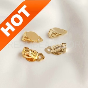 May include: Four gold-tone clip-on earring findings. The findings have a round pad and a spring-loaded clip.