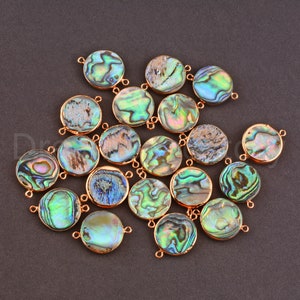May include: A collection of 18 round abalone shell connector charms with gold-toned metal accents. The charms have a variety of iridescent colors, including green, blue, and purple.