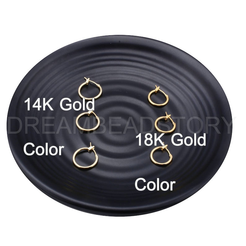 May include: Five gold hoop earrings on a black plate. The earrings are arranged in two rows, with the top row labeled "14K Gold" and the bottom row labeled "18K Gold".