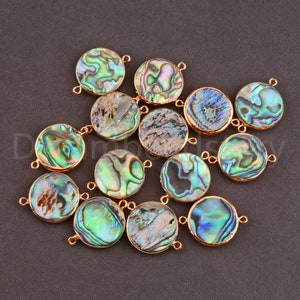 May include: A collection of 14 round abalone shell beads with gold-toned jump rings. The beads have a variety of iridescent colors, including green, blue, and purple.