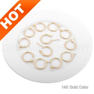 May include: A set of ten gold-colored hoop earrings. The earrings are small and delicate, and they are perfect for everyday wear.