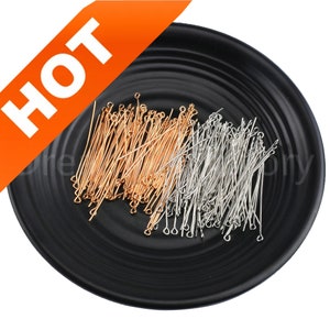 May include: A black plate filled with gold and silver head pins. The pins are used for jewelry making and crafting.
