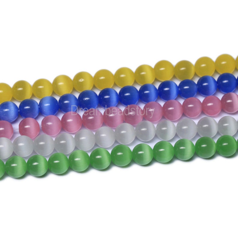 May include: A strand of round, smooth, cat's eye beads in five colors: yellow, blue, pink, white, and green.